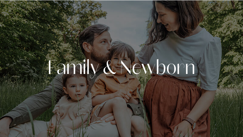Auf dem Bild sitzt eine junge Familie mit ihren Kindern im Graß. Die Kinder sitzen im Schoß des Vaters und Kuscheln mit ihm. Die Mutter schaut ihren Mann liebevoll an. Davor steht in weißer Schrift Familie & Newborn geschrieben. Das Bilder ist verlinkt auf die Seite Familie und Newborn Homepage von Jan Demann.